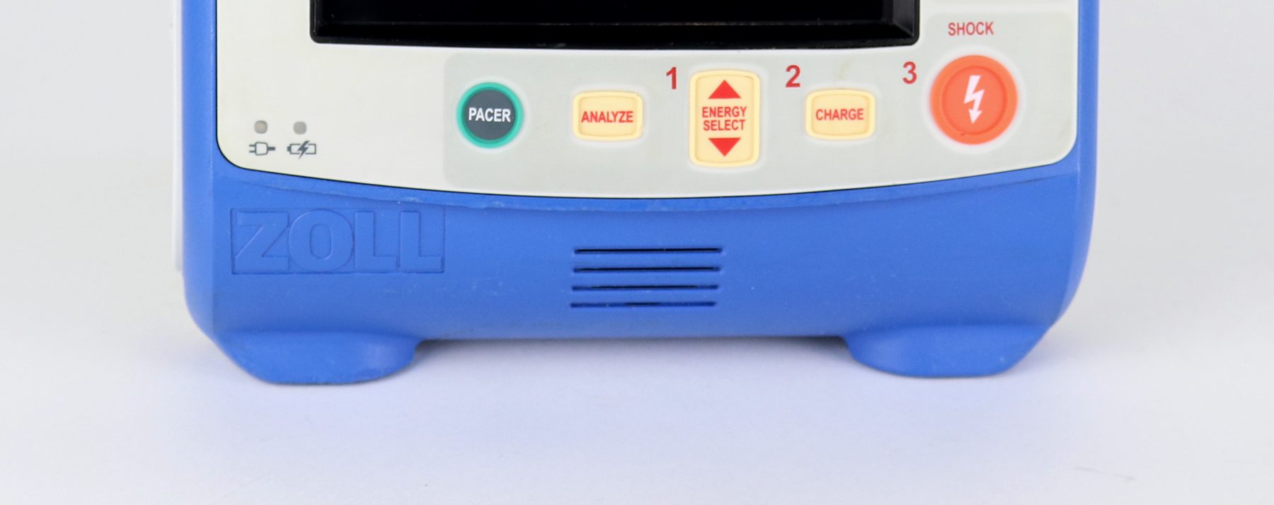 A close, wide view of the monitor’s lower control row — the pacer, analyze, energy select, charge, and shock keys — above its moulded base.