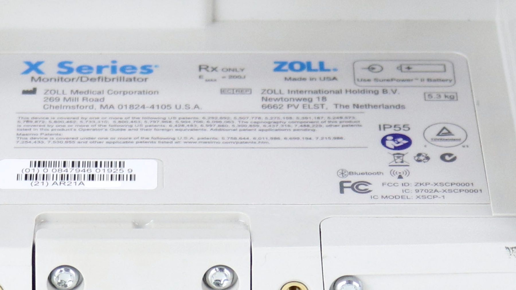 A close view of the identification plate moulded into the back of the monitor, printed with the model name, the manufacturer’s address, regulatory marks, and a barcode.